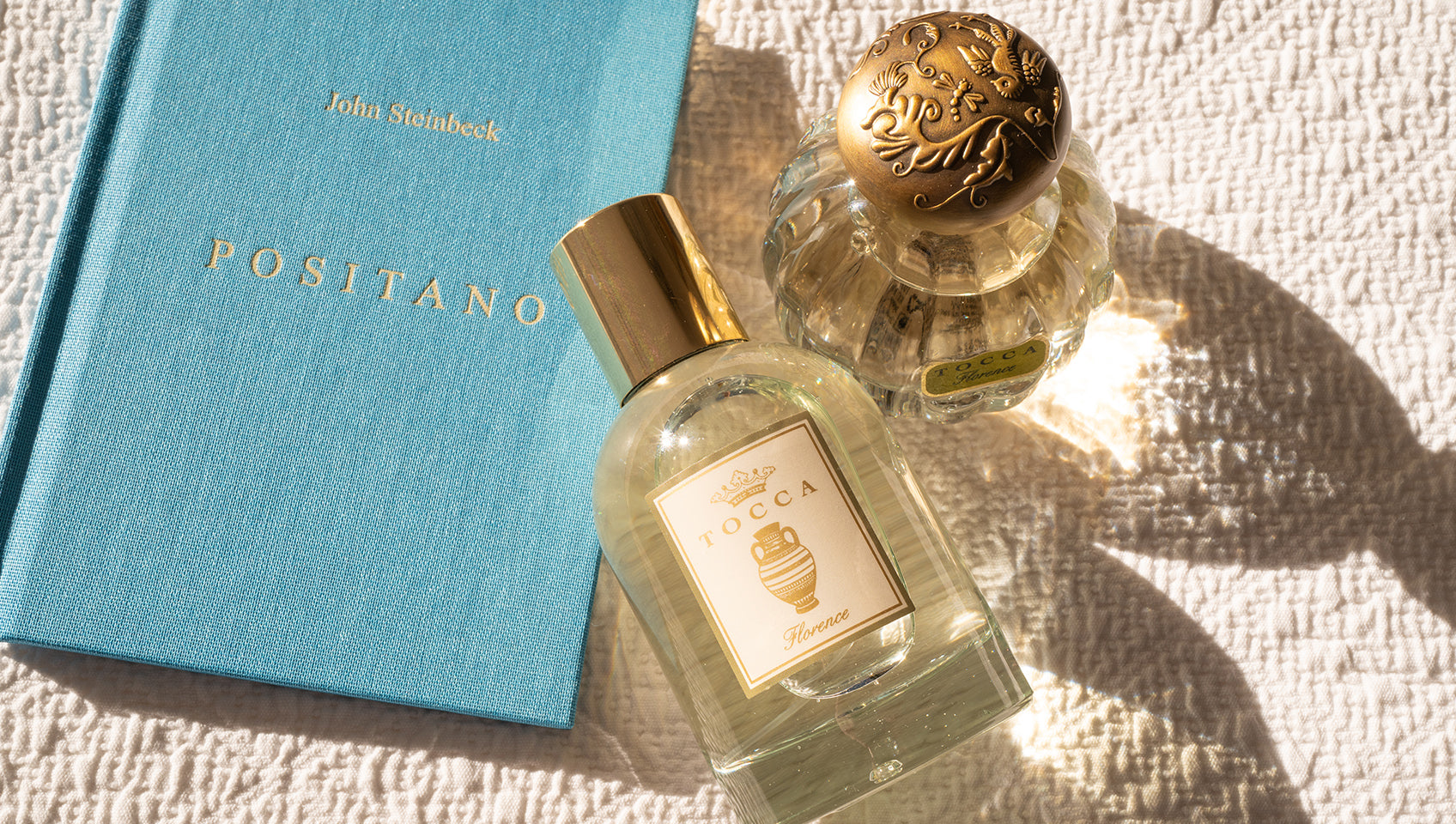 TOCCA Florence Eau de Parfum bottle next to John Steinbeck's Positano book